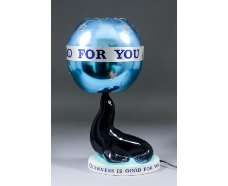 A Carlton Ware "Guinness" pottery seal electric table lamp with metal spherical shade, both printed "Guinness Is Good For You