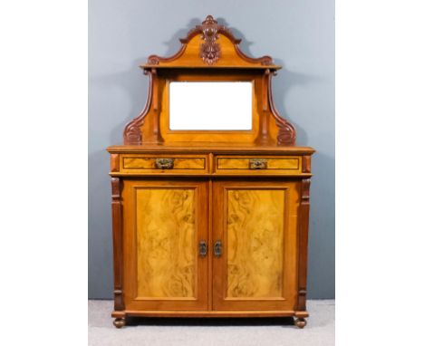 A late 19th Century Continental walnut chiffonier, the shaped back with carved cresting, fitted one shelf above mirror panel,