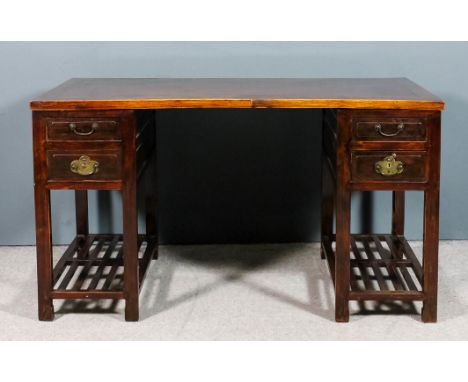 A Chinese stained wood and panelled kneehole desk with flush panel to top, fitted two drawers to each pedestal, on square leg