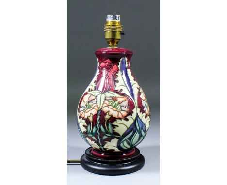 A Moorcroft pottery table lamp, tube-lined and decorated in colours with a carnation design, on turned wood stand, 11.25ins h