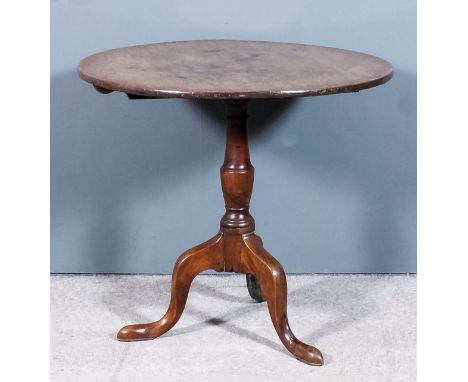 A George III mahogany circular tripod table with one piece top, on turned central column and cabriole legs with pad feet, 32i