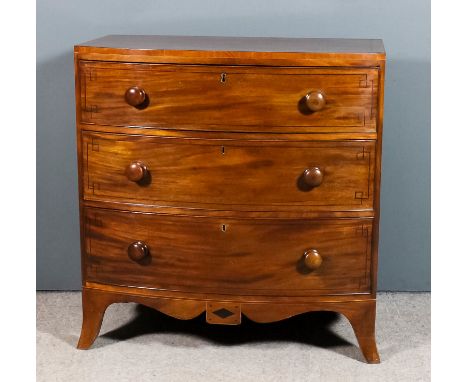 A late Georgian mahogany bow front chest, the square top edge inlaid with ebonised stringings, fitted three long drawers with