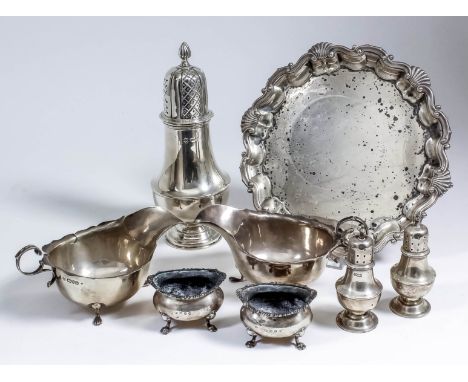 An Edward VII silver circular waiter, the shaped and moulded rim with shell and scroll mounts, on three claw and ball feet, 8