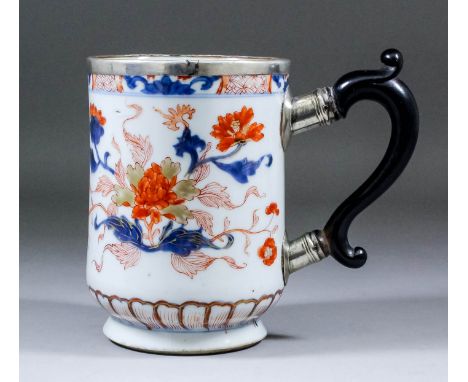 A Chinese porcelain "Imari" cylindrical tankard decorated with floral sprays, with silvery metal mount and replacement silver