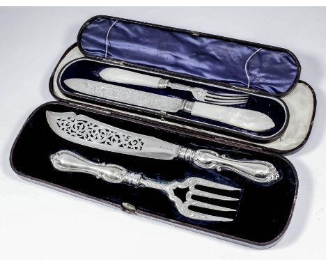 A pair of Victorian silver fish servers, the blades pierced and engraved with scroll ornament and with embossed scroll handle