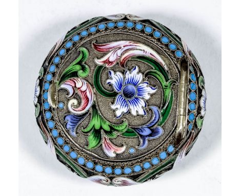A late 19th Century Russian silvery metal and champleve enamel circular snuff box decorated with floral and leaf scroll ornam