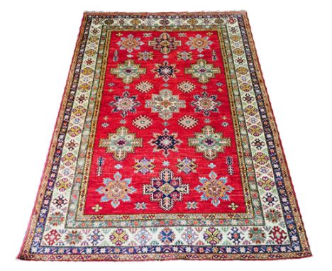 KAZAK CARPET, 250cm x 175cm, geometric medallions on a ruby field within corresponding guard stripes and ivory main border. 