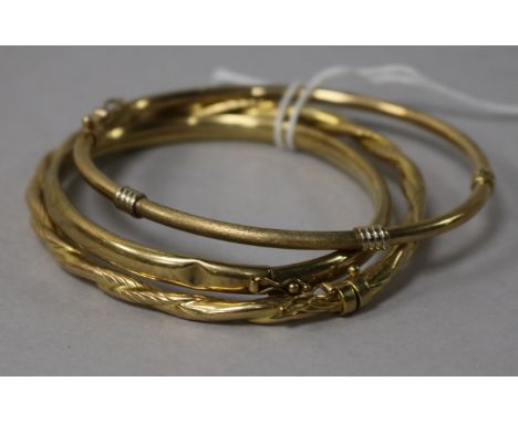 Two 9ct gold hinged bangles and a yellow metal hinged bangle.