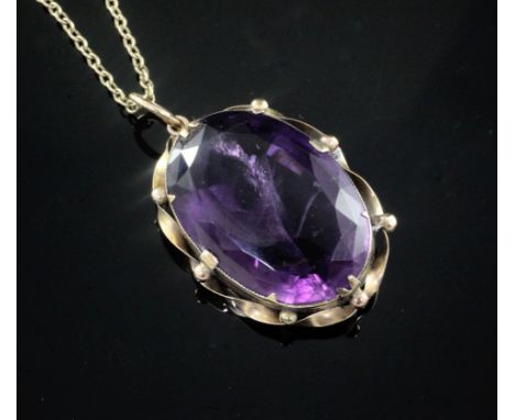 A large oval facet cut amethyst pendant in yellow metal mount on 9ct gold fine link chain, gross weight 27.6 grams, pendant 4