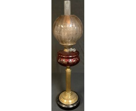 A Victorian brass columnar oil lamp, cranberry glass font, etched glass shade, 75cm high over chimney 