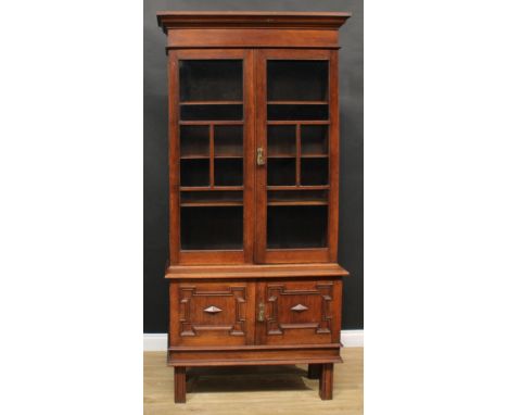 An early-mid 20th century oak bookcase, the base with two panel doors, 209cm high, 102.5cm wide, 38.5cm deep 