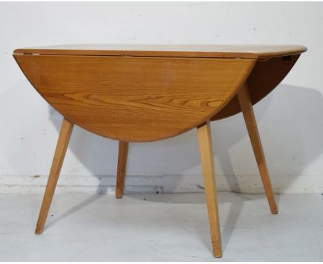 Ercol light elm oval drop leaf kitchen table raised on four beech splayed supports   Condition: 