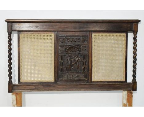 Early 20th Century oak headboard having carved central panel depicting two figures, flanked by caned panels and barley twist 