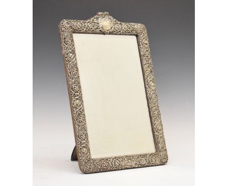 Edward VII embossed silver framed rectangular bevelled easel mirror having stylised foliate decoration and with cartouche eng