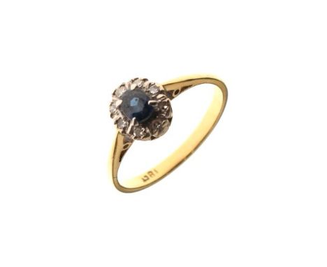 Dress ring set central sapphire coloured stone with a diamond surround, the shank stamped 18ct, size N½   Condition: 