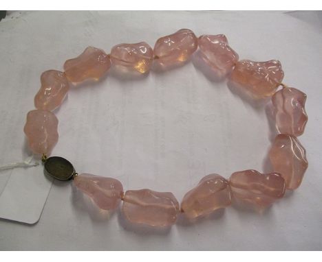 A Chinese rose quartz necklace with thirteen irregular shaped beads with a silver gilt clasp with pierced ornament