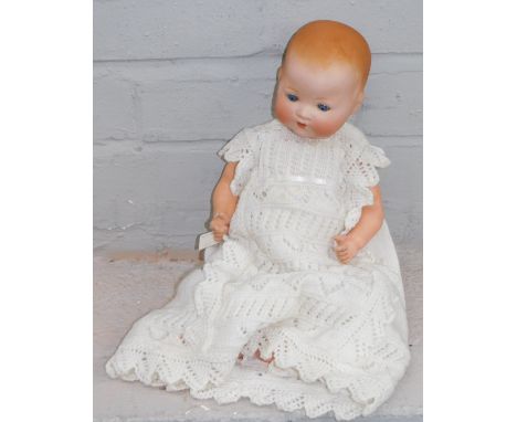 A German bisque porcelain doll, stamped AM Germany, and numbered 351-3-2K, on papier mache body, in knitted night dress. 