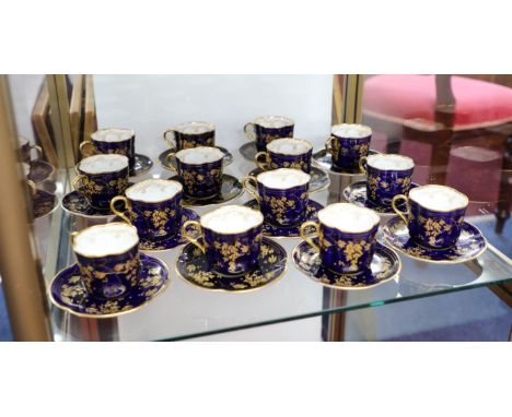 Royal Doulton, a Victorian set of fourteen teacups and saucers, with gilt decoration on a deep blue background.