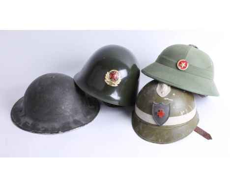 Four helmets including Chinese Jin Dong, Chinese pith helmet and English WWII helmet. Part of the Late Reverend Geoffrey Garn