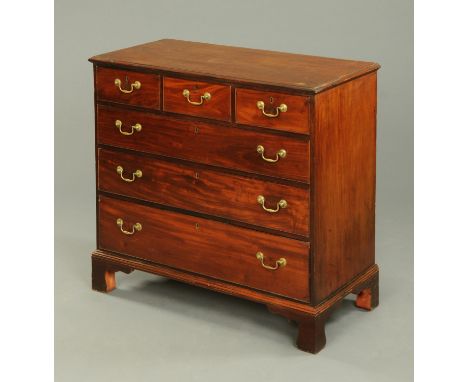 An early 19th century mahogany chest of drawers, with three short and three long graduated drawers with brass swans neck drop