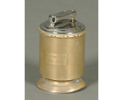 A table cigarette lighter, housed in a cylindrical silver case, the case stamped "Garrard & Co., Regent Street", London hallm