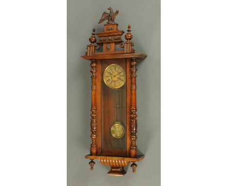 A late Victorian walnut regulator wall clock, with composition eagle finial and two-train striking movement.