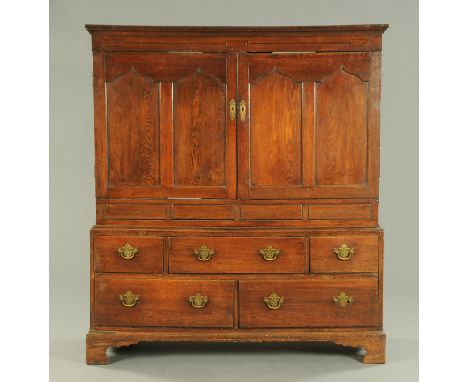 A George III oak housekeepers press, with moulded cornice above a pair of panelled doors opening to shelves and the base fitt