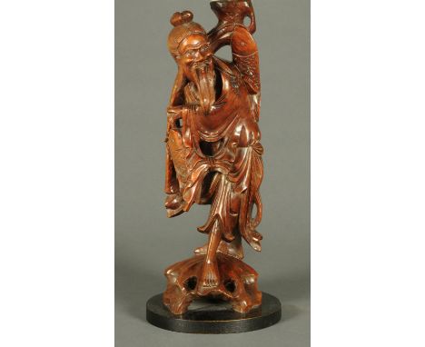 A Chinese carved hardwood figure, fisherman, converted to a table lamp.  Height excluding light fitting 48 cm. 