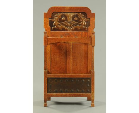 An Arts & Crafts oak hall stick stand, with relief embossed metal panels and with drip tray to base.  Width 56 cm, height 105
