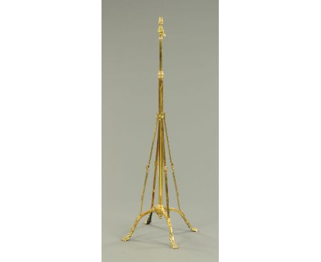 A Victorian brass lamp standard, raised on four angled supports and short feet terminating in paws.  