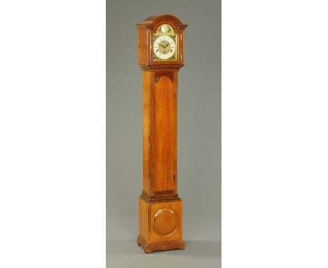 A walnut grandmother clock, with brass dial and three-train spring driven movement striking on eight gongs, with long trunk d
