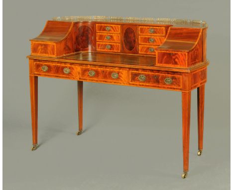 An Edwardian inlaid mahogany Carlton House style desk, with brass gallery and fitted with a series of drawers, cupboards and 