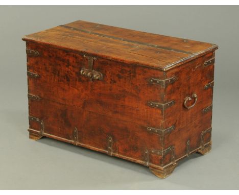 A 19th century Colonial hardwood and iron bound trunk, with carrying handle to either side and raised on later bracket feet. 