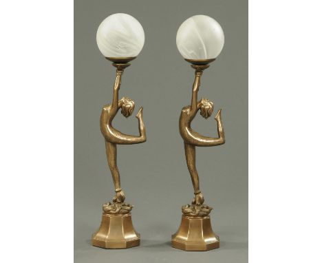 A pair of Art Deco style composition figural table lamps, each a female figure with snake holding aloft a globe.  Height 63 c