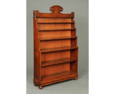 A late Regency/William IV mahogany waterfall bookcase, with six open shelves, shallow drawer to base and raised on short bun 