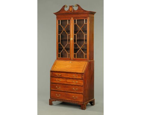 A George III mahogany bureau bookcase, with swans neck pediment above a pair of glazed doors with wooden astragals enclosing 