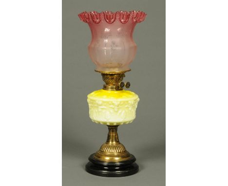 A Victorian brass oil lamp, with cranberry glass shade.