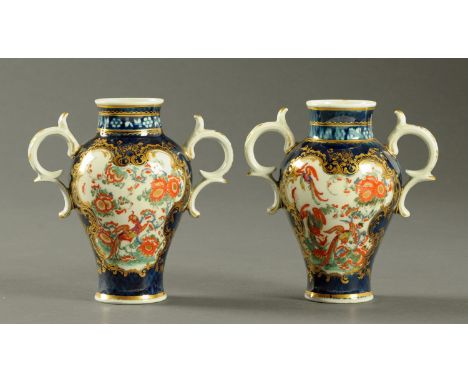 A pair of early Worcester Scale Blue porcelain two handled vases, decorated with Kakiemon style panels in the so called "Jabb