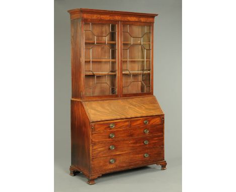 A George III mahogany bureau bookcase, in two sections, with a moulded cornice above a crossbanded frieze and pair of glazed 