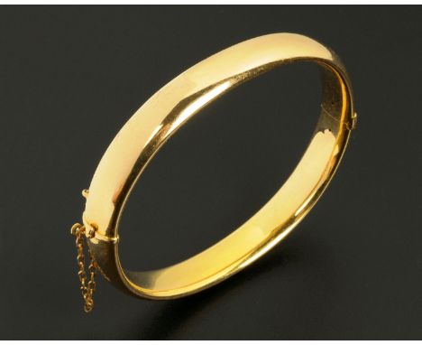 A 15 ct gold bangle, with safety chain, 17.1 grams (see illustration). CONDITION REPORT: The safety is present and intact.  T