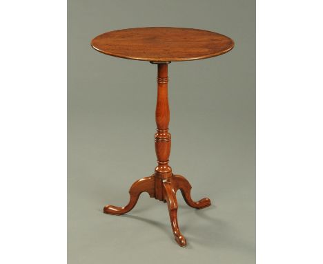 A George III mahogany oval tripod table, with ring turned vase and baluster column and raised on downswept legs terminating i