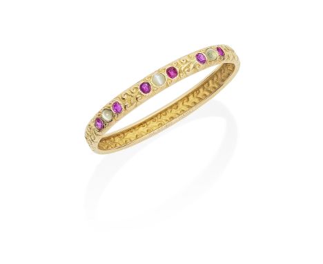 TIFFANY: ART NOUVEAU GOLD, RUBY AND CAT'S EYE CHRYSOBERYL BANGLE, CIRCA 1882Chased throughout in a breaking wave pattern, the