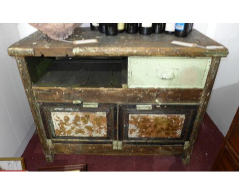 An early 20th century industrial work bench with remnants of factory green paint and gilt gesso floral panel doors and single