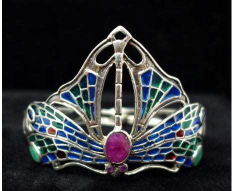 A sterling silver Art Nouveau style cuff bangle in the form of a stylised dragonfly inset with plique a jour enamels, rubies,