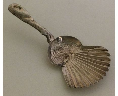 A Georgian silver fluted caddy spoon with bright cut decoration. Approx. 7 grams. Est. £20 - £30.