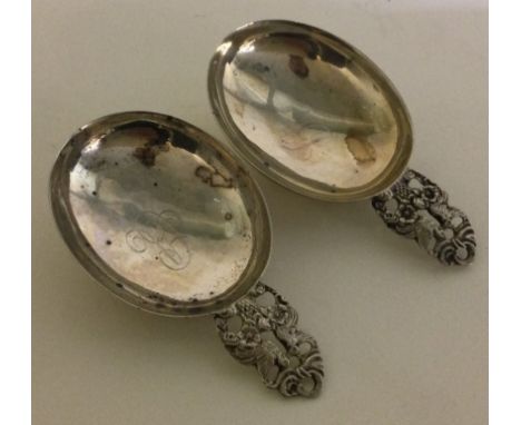 A heavy pair of Continental silver caddy spoons pierced with birds. Approx. 34 grams. Est. £40 - £60.