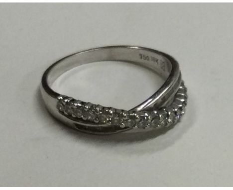 An unusual 18 carat gold baguette cut crossover ring. Approx. 3 grams. Est. £200 - £300.