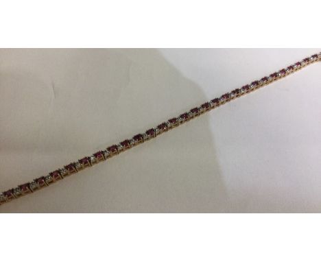 An attractive ruby and diamond line bracelet in 9 carat setting. Approx. 7.5 grams. Est. £250 - £300.