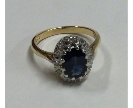 A large oval sapphire and diamond crossover ring in 18 carat gold setting. Approx. 4.4 grams. Est. £200 - £300.