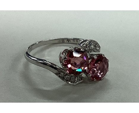 A unusual tourmaline and diamond crossover ring in platinum setting. Est. £600 - £800.